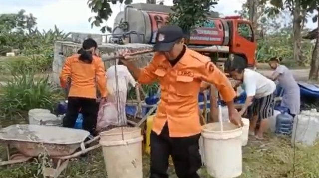 Petugas BPBD Bojonegoro mendistribusikan air bersih kepada warga.
