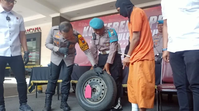 Kapolres Tulungagung AKBP Taat Resdi (tengah) menunjukkan barang bukti berikut tersangka pelaku perampokan/pencurian dengan modus kempes ban saat pers rilis di Mapolre Tulungagung, Senin (28/10/2024) (ANTARA)