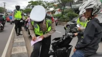 Potret seorang pengendara ditilang oleh polisi. (Foto: Zona Honda)