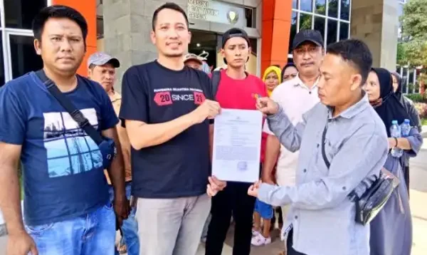 Muhammad Cholid, korban arisan bodong menunjukkan STTLPM didampingi korban yang lain saat di Mapolres Gresik, Senin (4/11/2024).